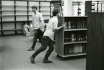 Male students shifting books in Nyselius Library, Reference Section