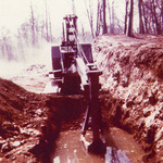Crane digging in a water-filled pit
