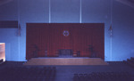Inside Alumni Hall gym with a view of the stage and podium